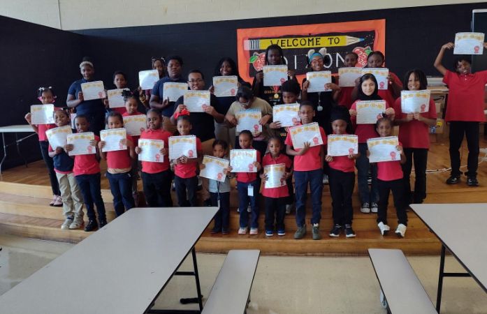  Students standing on the stage holding certificates